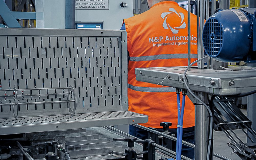 Técnico de N&P Automation operando una línea de producción automatizada con tablero de control